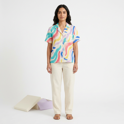 Model wearing abstract wave shirt with cream trousers